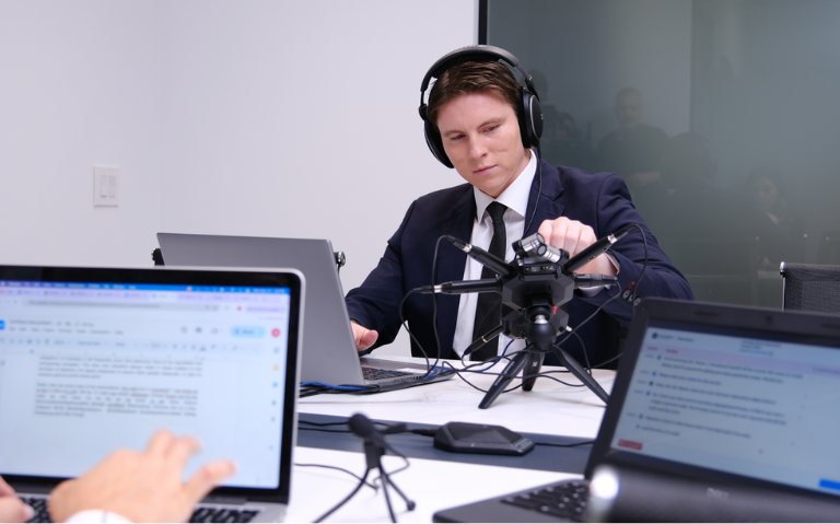 Digital reporter sets up equipment at deposition