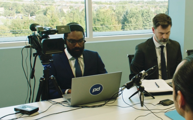 A videographer and interpreter set at a deposition